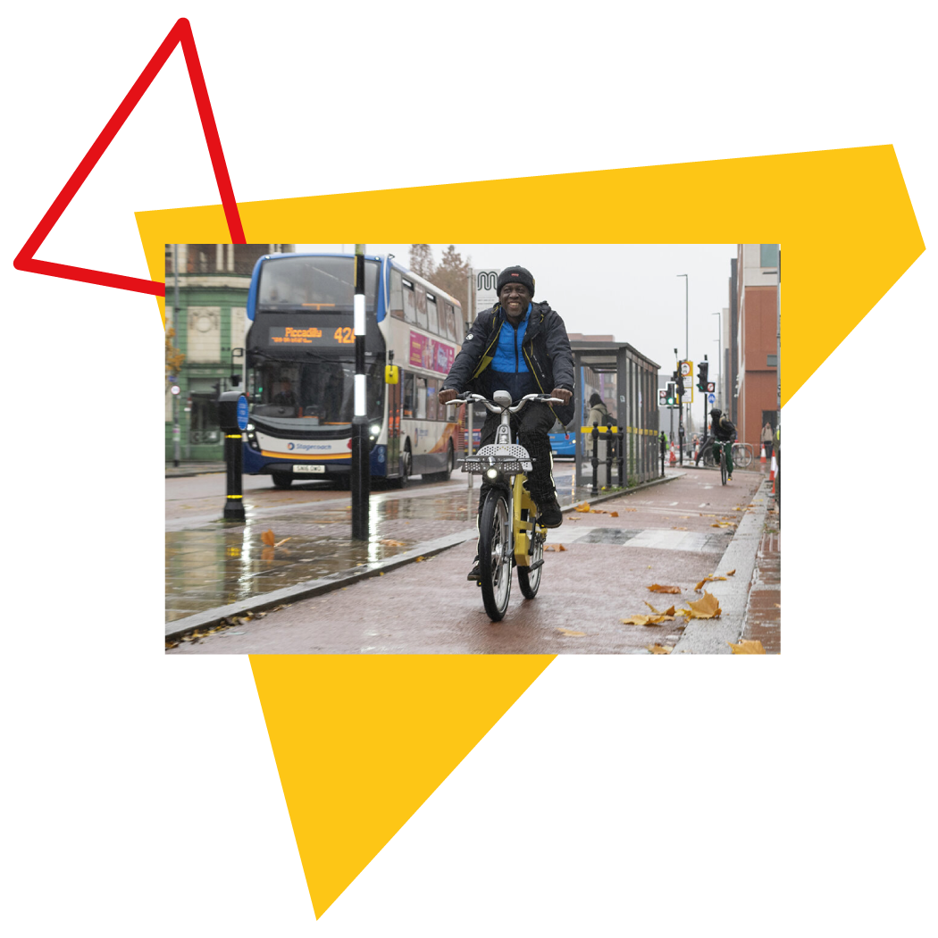 Man riding a cycle hire bike on a city centre cycle lane with bus in the background
