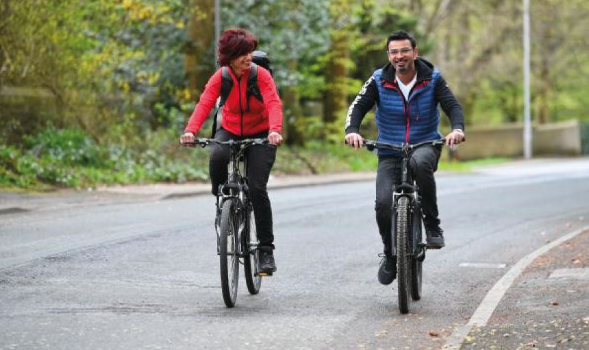People riding a bike down a road