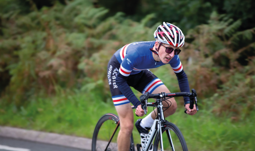 Person on a road bike in Manchester Wheelers kit